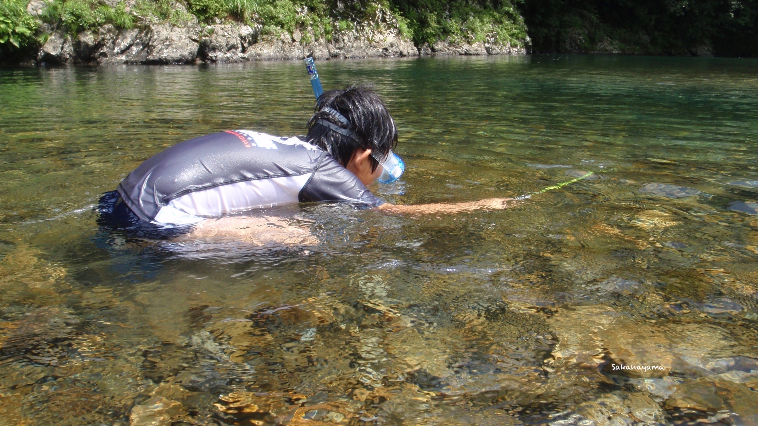 エビタマを持って川で遊ぶ少年